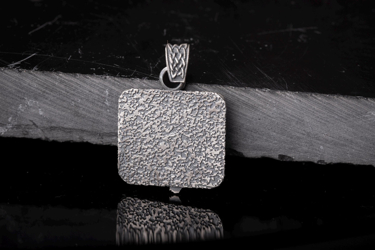 Silver textured square pendant with intricate woven detail on the bail, showcasing the Scandinavian Viking Pendant design in a rustic, polished finish.