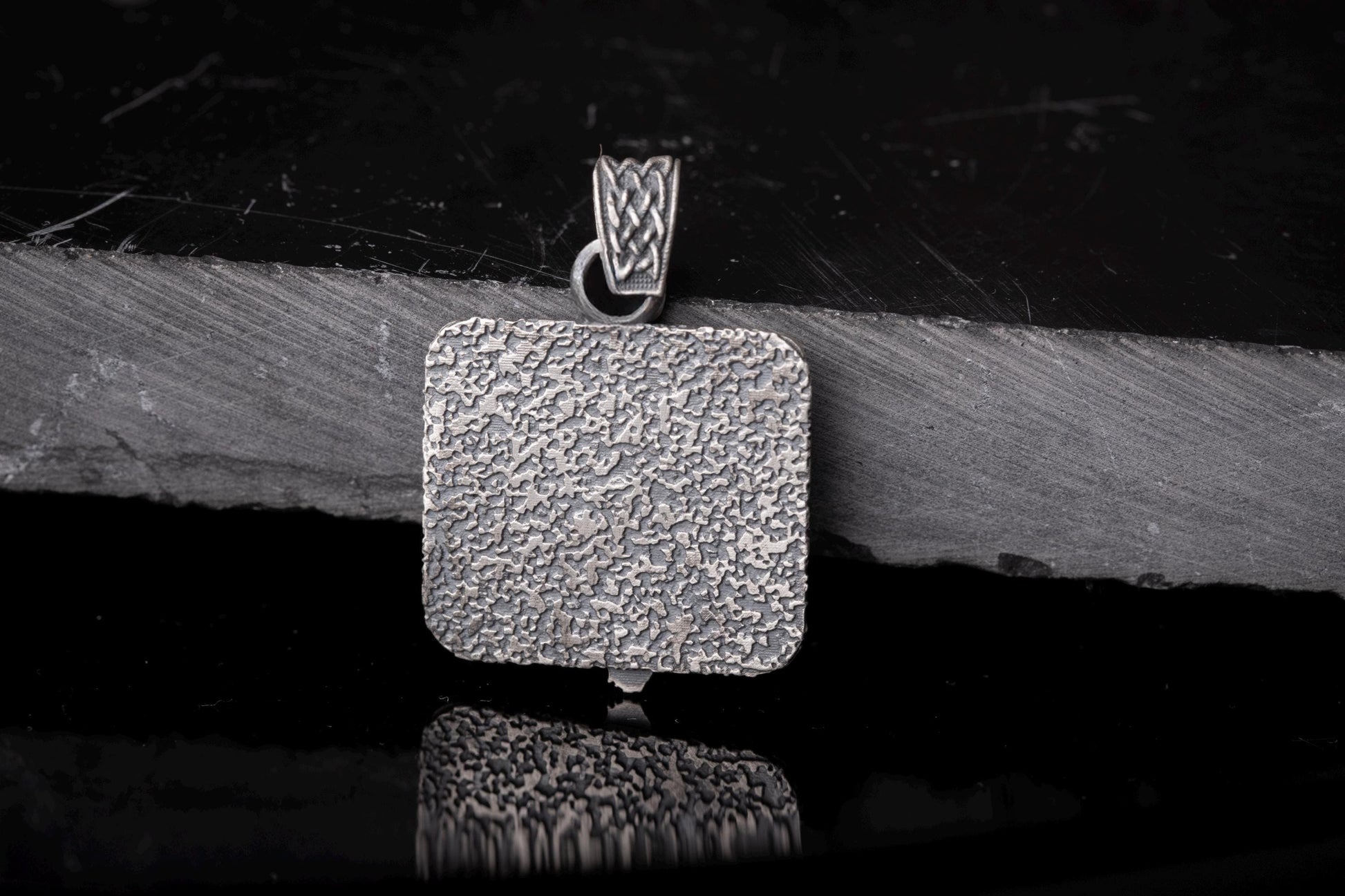 Silver textured square pendant with intricate woven detail on the bail, showcasing the Scandinavian Viking Pendant design in a rustic, polished finish.