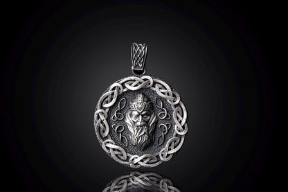 Silver Odin Pendant featuring an intricately detailed Norse god face in the center, surrounded by a decorative Celtic knot border in polished silver, reflecting craftsmanship and mythology.