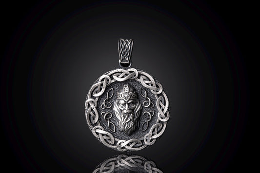 Silver Odin Pendant featuring an intricately detailed Norse god face in the center, surrounded by a decorative Celtic knot border in polished silver, reflecting craftsmanship and mythology.