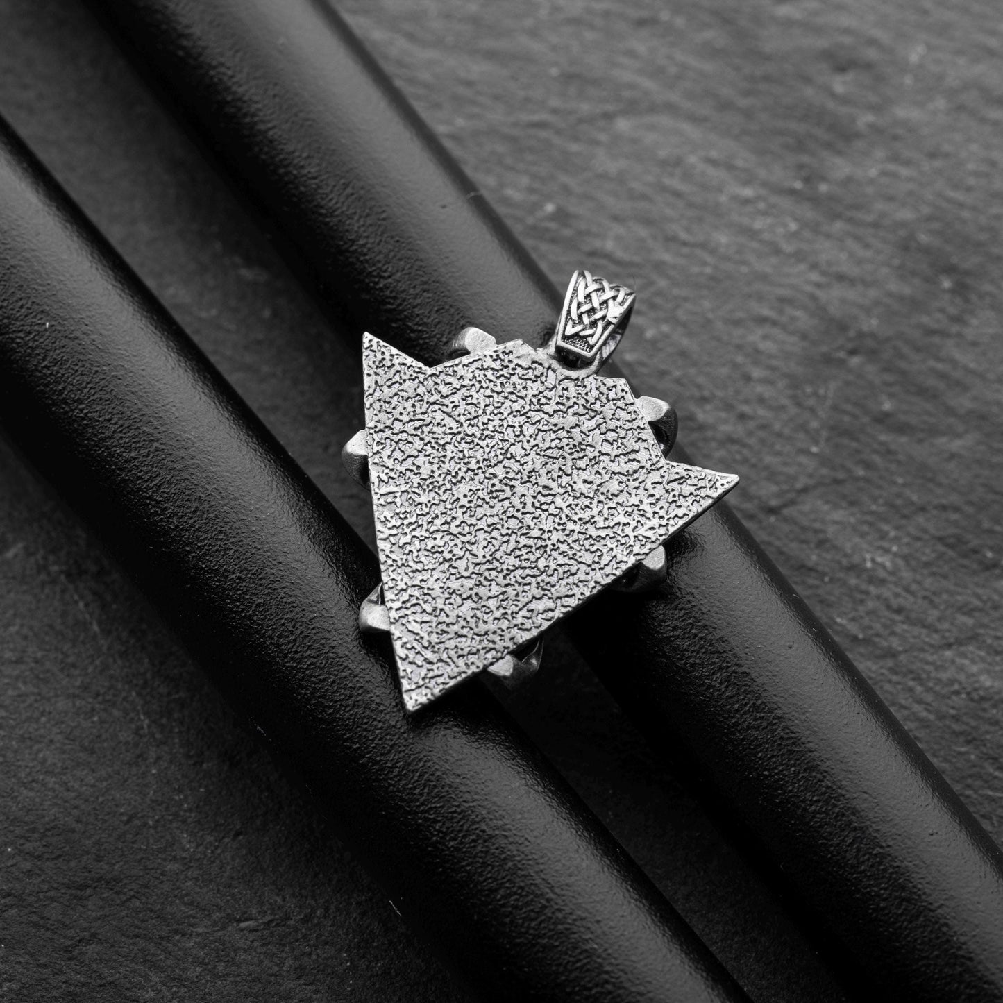 Sterling Silver Arrowhead Wolf Pendant featuring a textured arrowhead shape with intricate detailing, displayed on a black background highlighting its craftsmanship and silver finish.