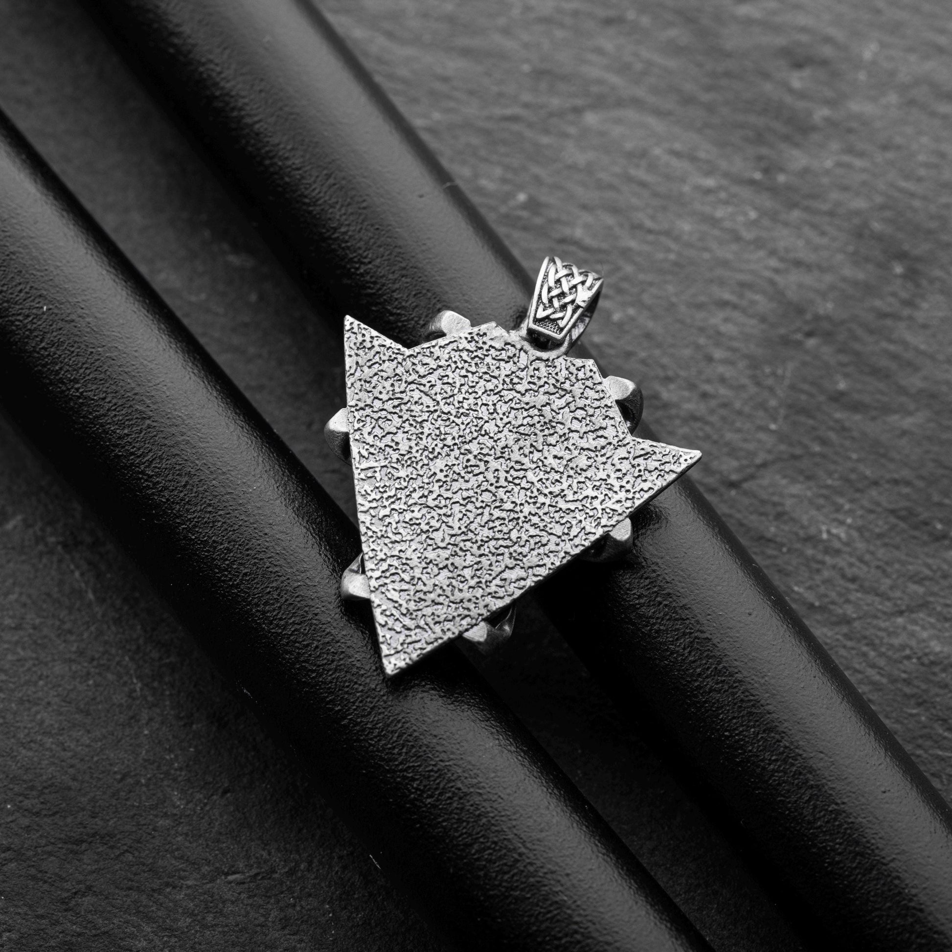 Sterling Silver Arrowhead Wolf Pendant featuring a textured arrowhead shape with intricate detailing, displayed on a black background highlighting its craftsmanship and silver finish.