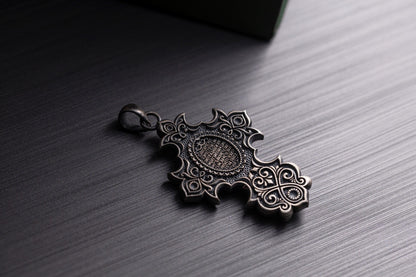 Jesus Crucifix Pendant featuring intricate filigree design in silver tone, lying on a dark textured surface, ideal as a chain necklace accessory.