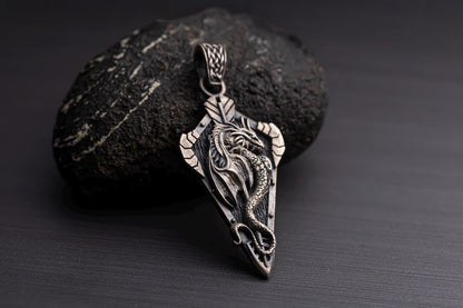 Sterling Silver Dragon Arrowhead Pendant featuring a detailed dragon design resting on a dark textured stone, ideal for silver jewellery and chain necklace styles.